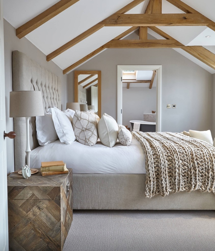 Hygge Bedroom with neutral paint, exposed wood beams, cozy throw